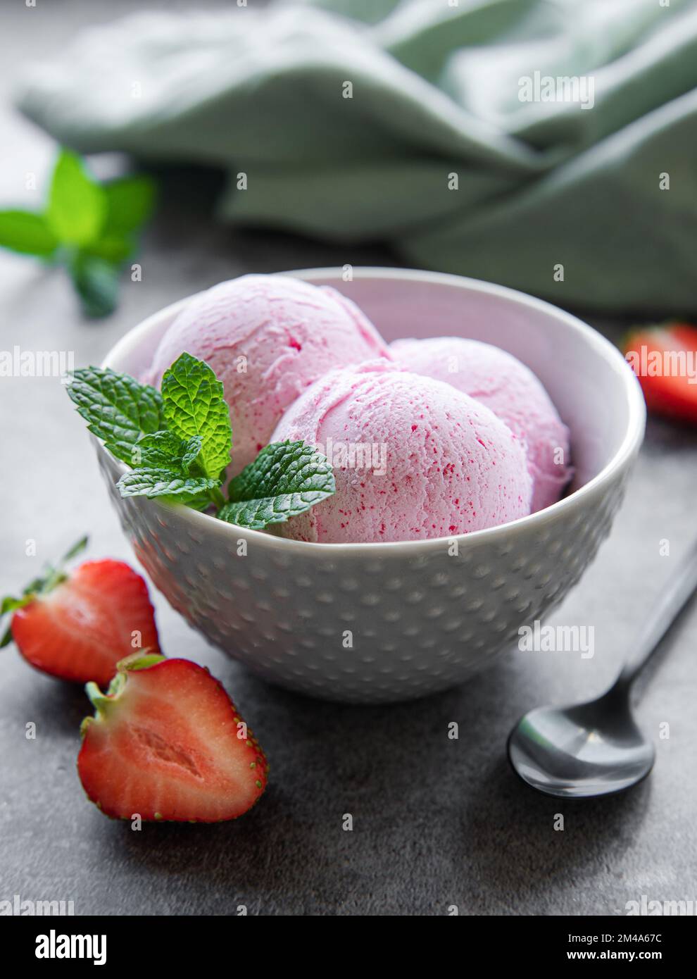 Gelato alla fragola fatto in casa con fragole fresche. Dolce bacche dessert estate. Sfondo concreto Foto Stock