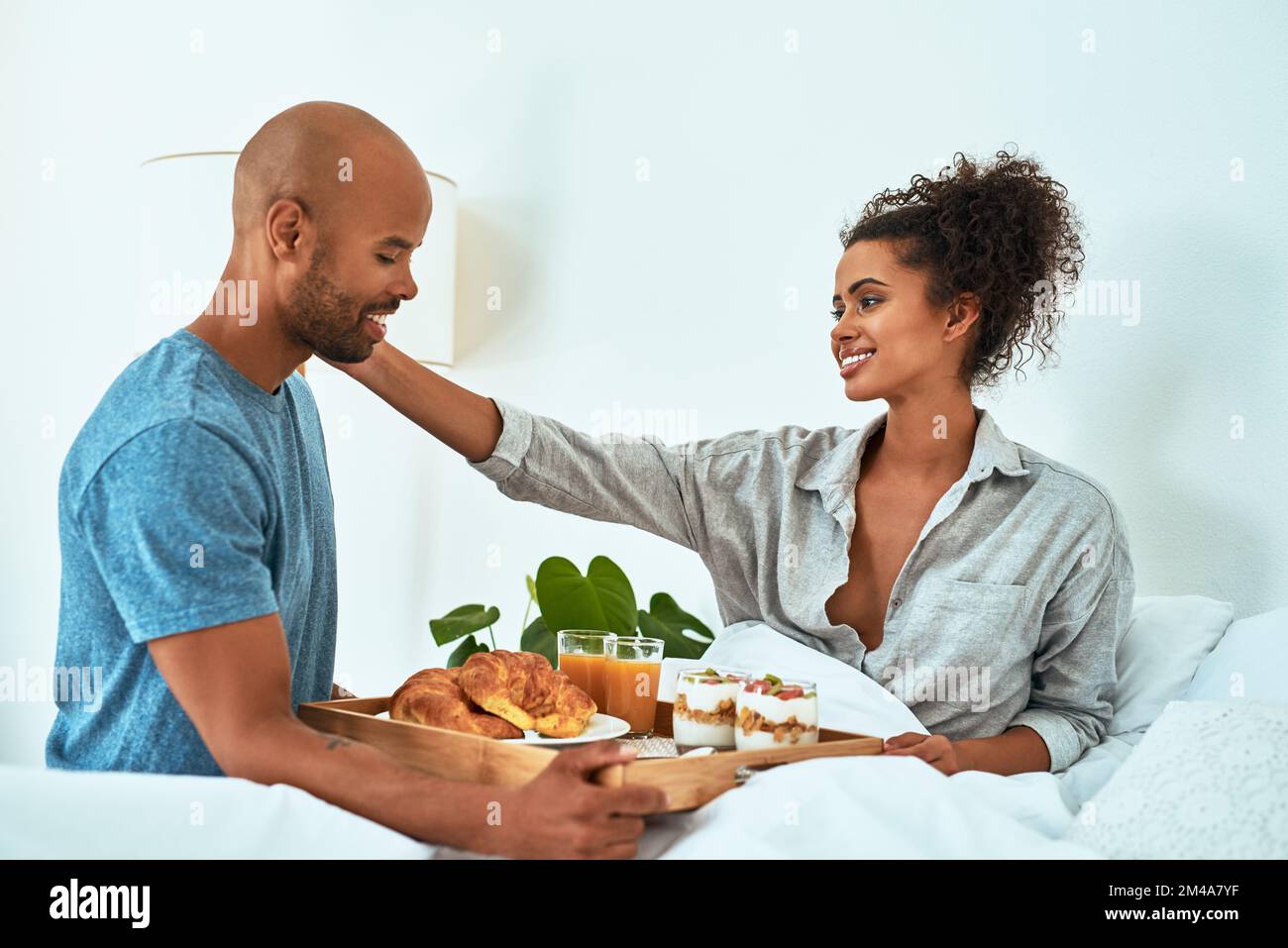 Youre così dolce per portarmi la colazione. una giovane coppia affettuosa che ha fatto colazione a letto. Foto Stock