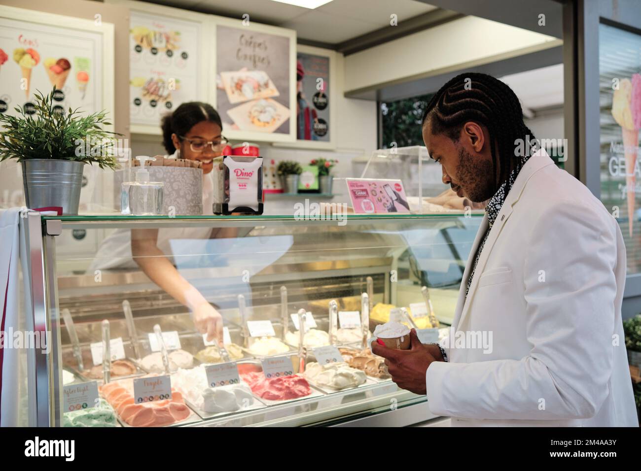 Cliente che acquista una terrina di gelato in un negozio Foto Stock
