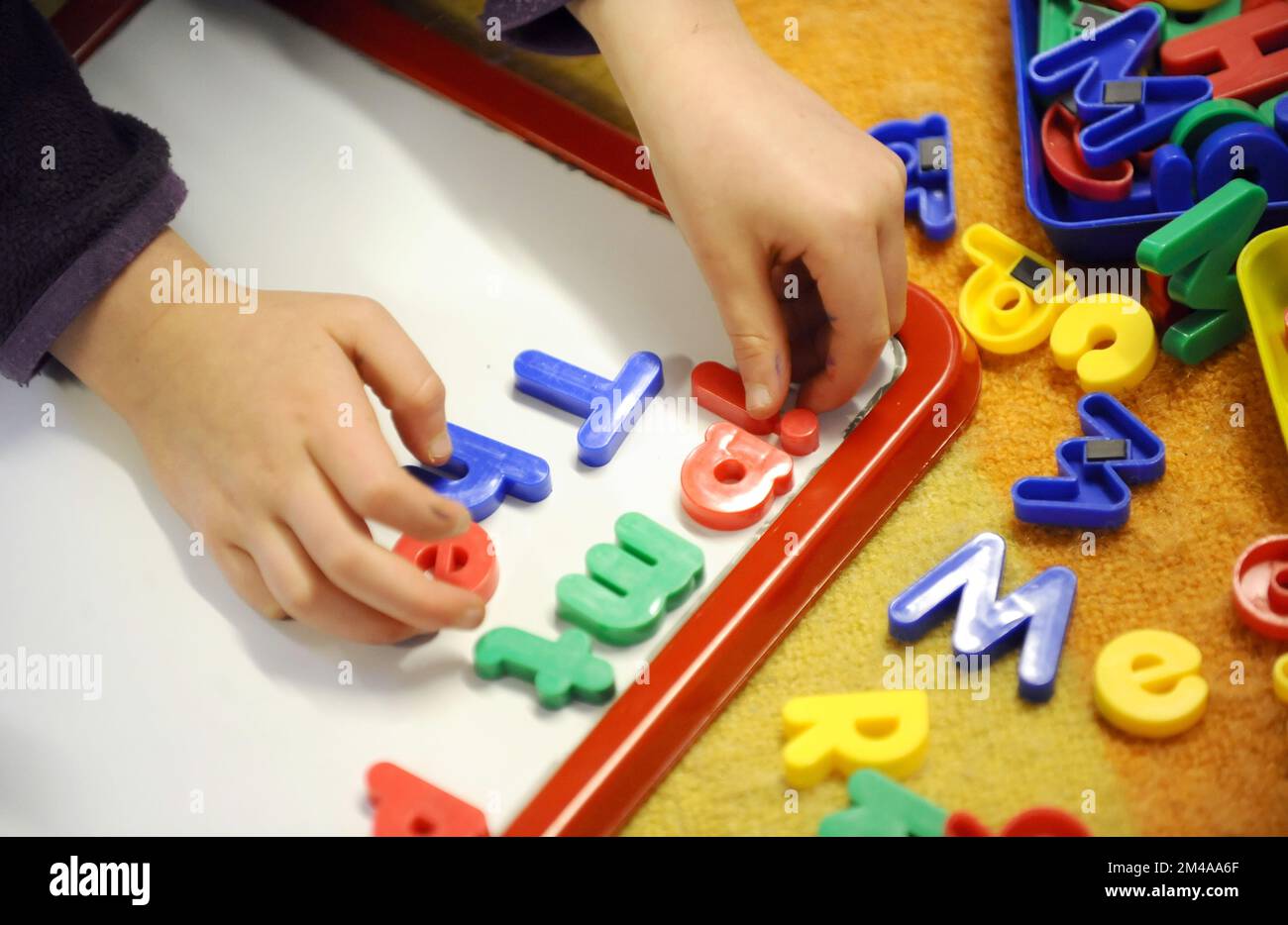 Foto del file datata 08/02/12 di un bambino della scuola elementare al lavoro in classe. I genitori del credito universale (UC) che vogliono lavorare o aumentare le loro ore di lavoro sono tenuti "prigionieri per l'alto costo dell'assistenza all'infanzia", hanno avvertito i parlamentari. Il sostegno alle spese per l'assistenza all'infanzia attraverso i benefici è sufficiente a coprire l'orario a tempo parziale e impedisce ai genitori di lavorare più a lungo, secondo una relazione della commissione per il lavoro e le pensioni. Data di emissione: Martedì 20 dicembre 2022. Foto Stock