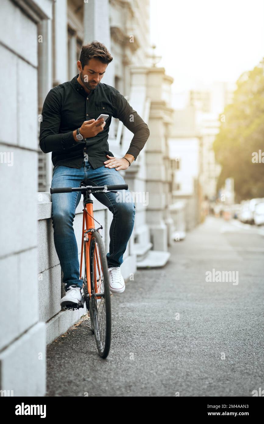 Indovina tutto aspetta. Foto a tutta lunghezza di un bel giovane che invia un testo mentre viaggia per la città. Foto Stock