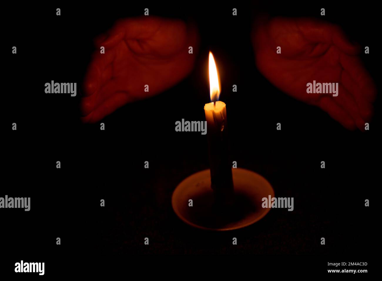 candela fiamma illumina una mano femmina in una stanza Foto Stock