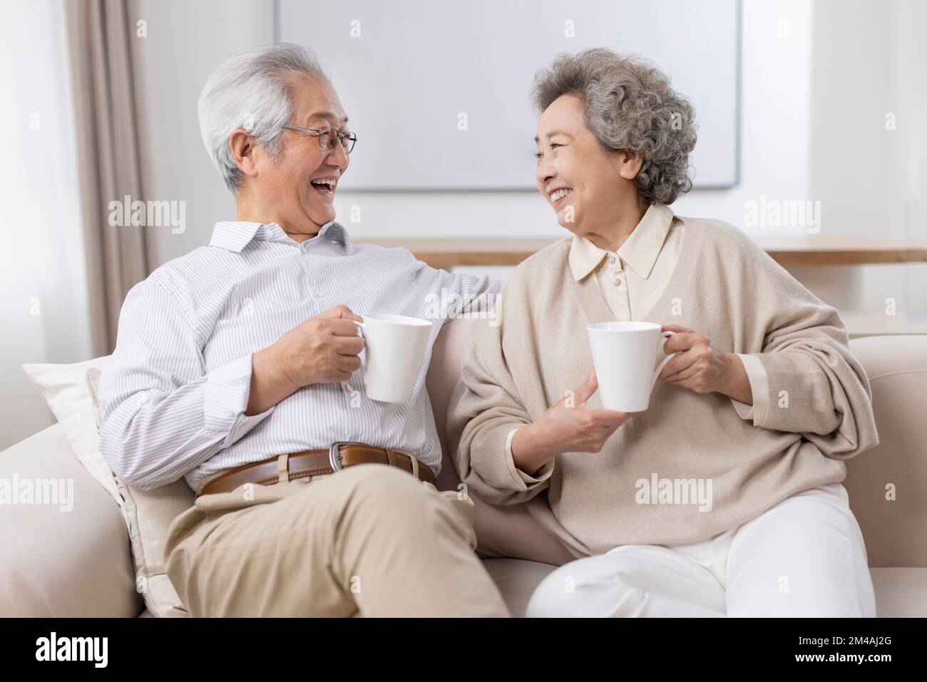 Allegro coppia cinese anziana bere caffè a casa Foto Stock