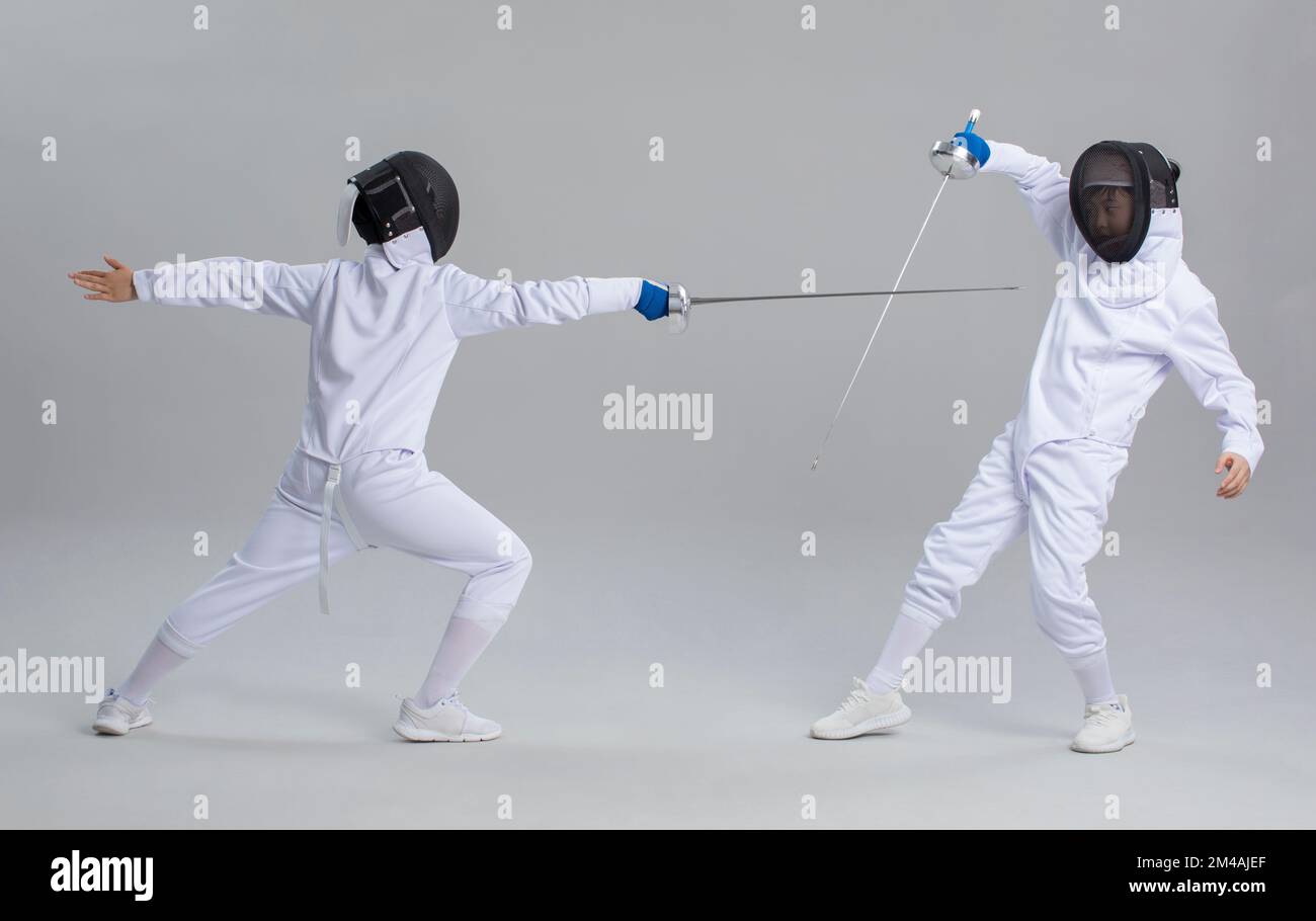 Simpatici ragazzi cinesi in tuta da scherma Foto Stock