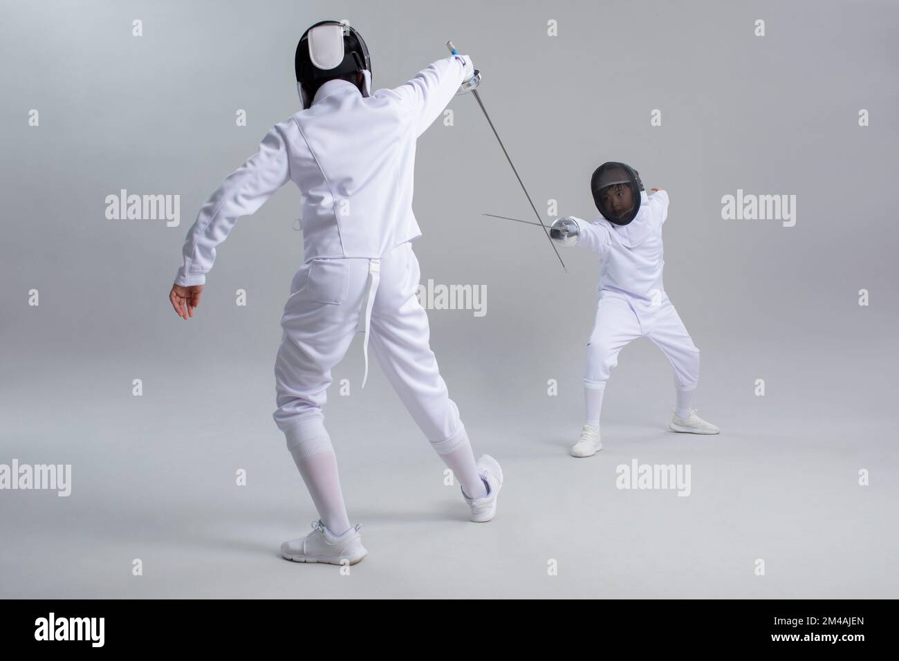 Simpatici ragazzi cinesi in tuta da scherma Foto Stock