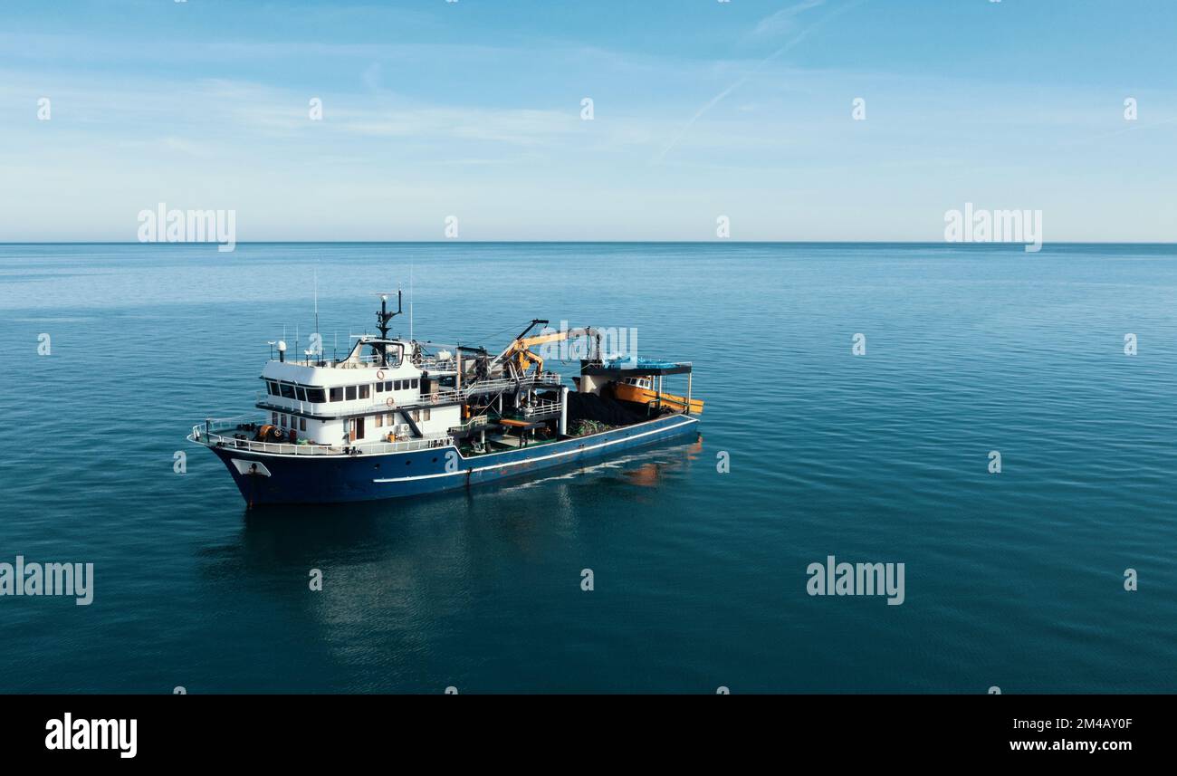 Barca da pesca vista aerea dal drone sulla superficie del mare. Industria della pesca e dei frutti di mare. Foto Stock