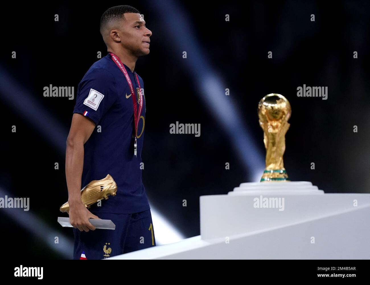 Vincitore del Golden Boot, il francese Kylian Mbappe sembra sconsolato mentre passa davanti al Trofeo della Coppa del mondo FIFA dopo aver subito la sconfitta in Argentina nella finale della Coppa del mondo FIFA al Lusail Stadium, Qatar. Data immagine: Domenica 18 dicembre 2022. Foto Stock