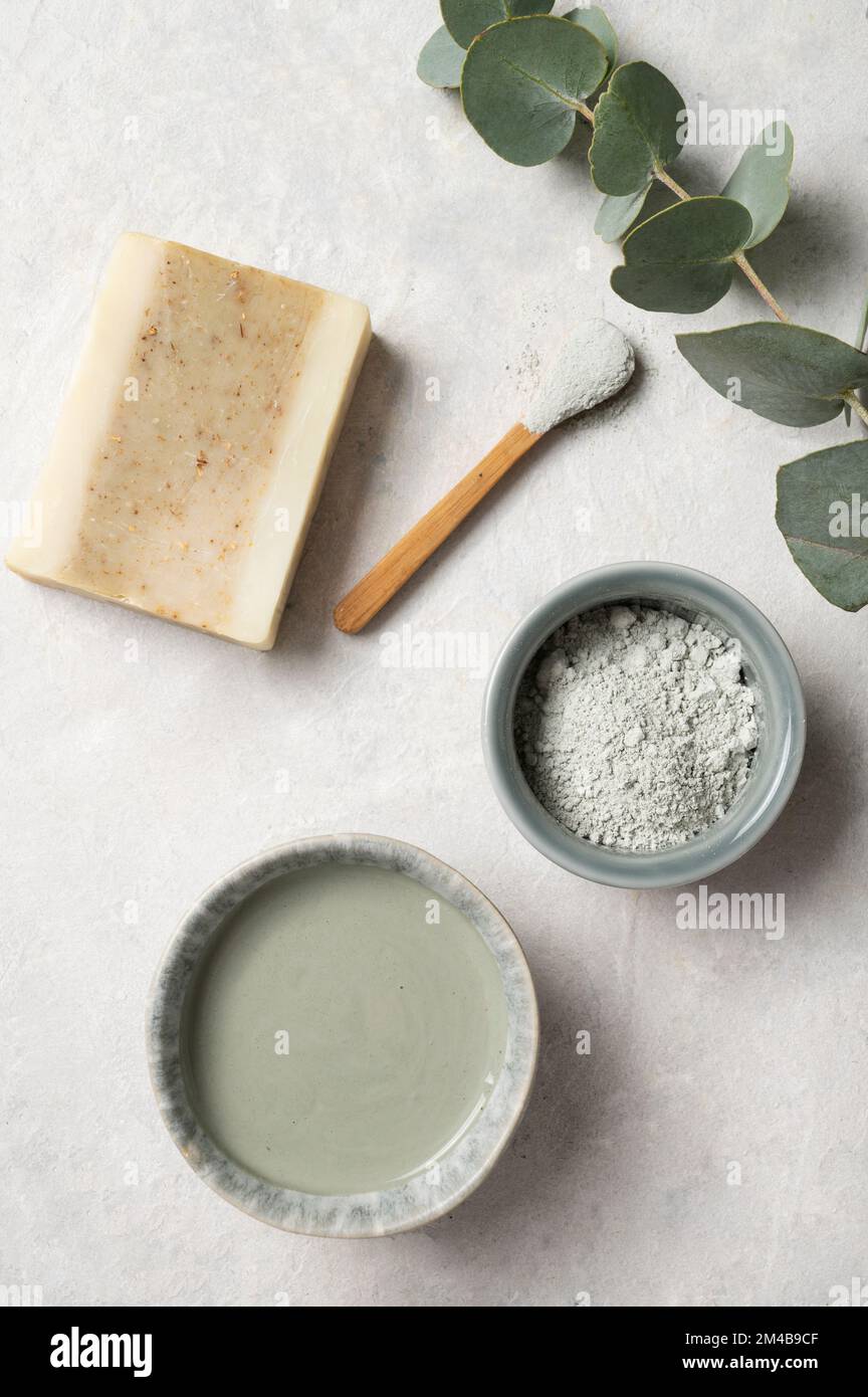 Argilla verde cosmetica organica, sapone e ramificazione di eucalipto su uno sfondo testurizzato bianco. Il concetto di spa e benessere. Vista dall'alto. Foto Stock