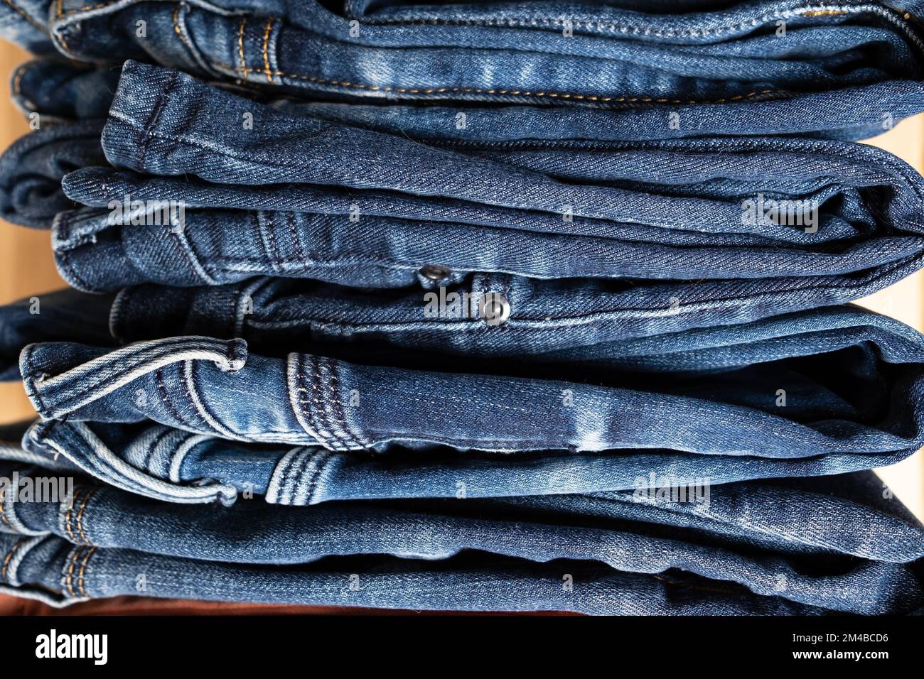 Jeans ordinatamente ripiegati in un mucchio. Concetto del settore commerciale, vendite. Primo piano. Foto Stock