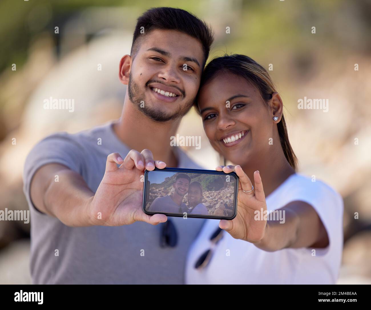 Felice coppia, selfie telefono e schermo in natura, sorriso e memoria in vacanza al sole d'estate. Coppia, amore e romanticismo con l'immagine digitale Foto Stock