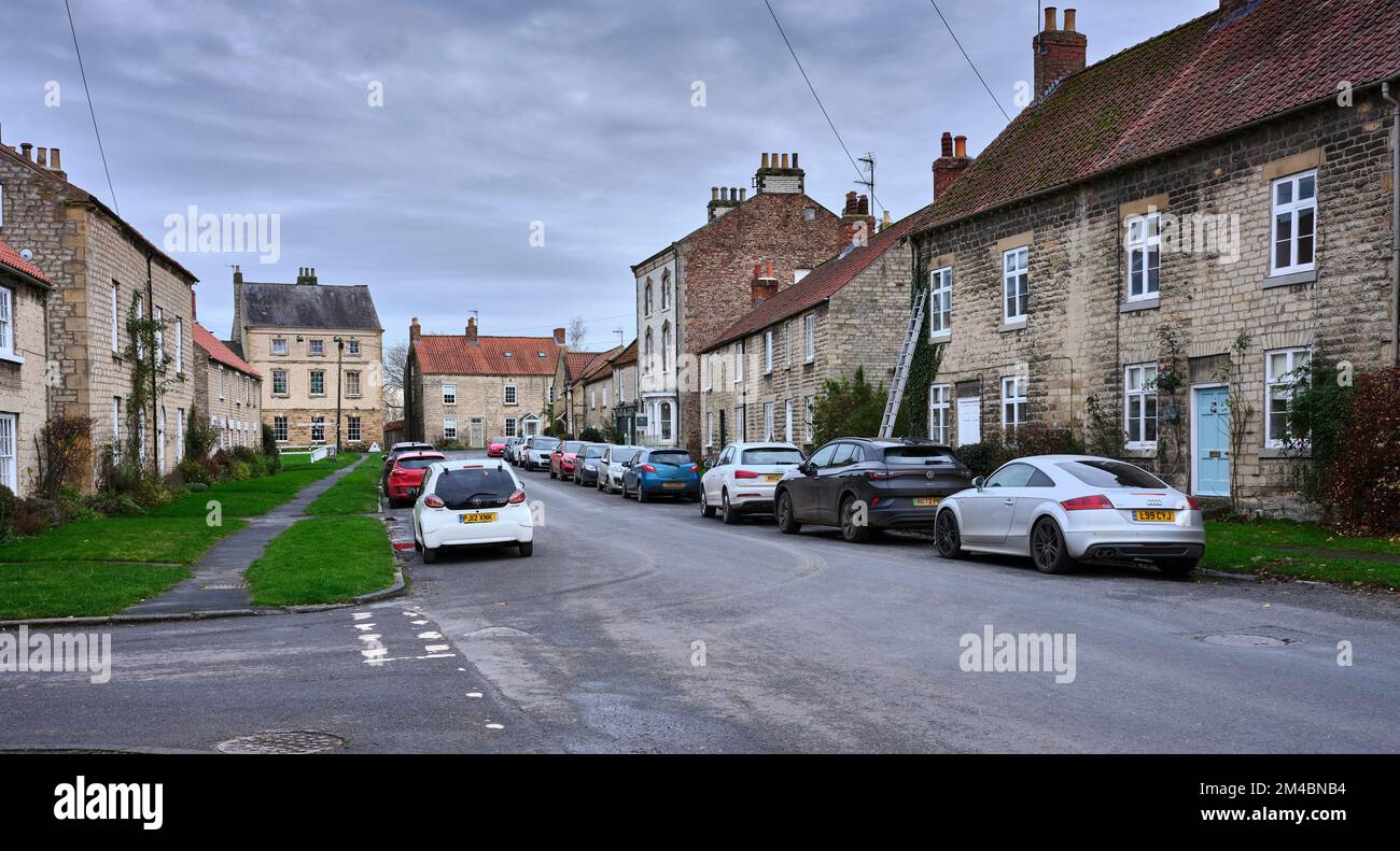 Una vista ad est lungo Park Street verso High Street, (B1257), con tradizionali case in pietra a 2 e 3 piani con tetti in tegole e ardesia. Hovingham Foto Stock