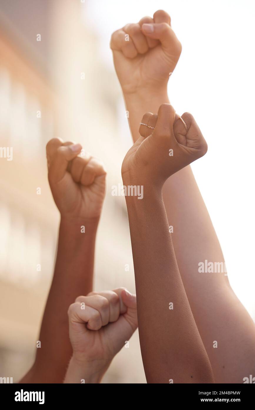 Mani pugno e giustizia del potere da parte delle persone in protesta per la libertà, l'uguaglianza e il cambiamento in una strada. Comunità, azione e raduno di governo da uomo e. Foto Stock