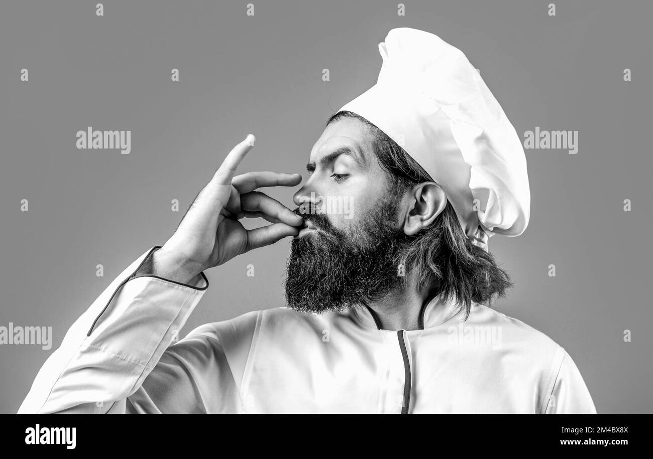 Chef, cucinare facendo gustoso gesto delizioso baciando le dita. Cappello da cuoco. Bianco e nero Foto Stock