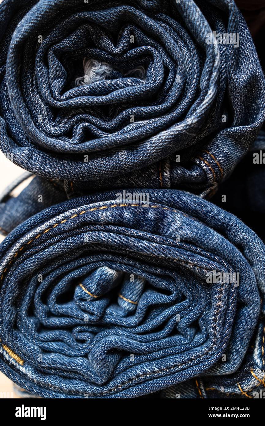 Jeans arrotolati e accatastati. Concetto del settore commerciale, vendite. Foto Stock