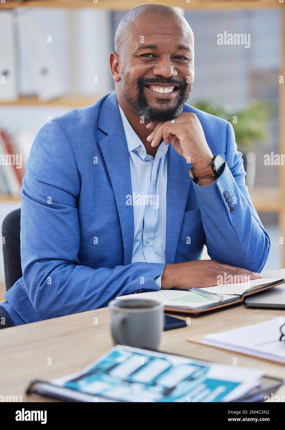 Uomo nero felice, manager aziendale e ceo che lavorano alla moderna scrivania da ufficio come investitore finanziario, commerciante di borsa e lavoratore aziendale in Nigeria Foto Stock