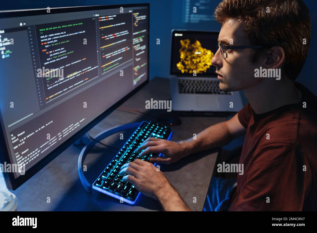 Vista del profilo di giovani sviluppatori programmazione in casa ufficio, uomo in camicia e occhiali scrivere codice sul computer PC controllo database. Sviluppo di programmi e concetto di scienza dei dati Foto Stock