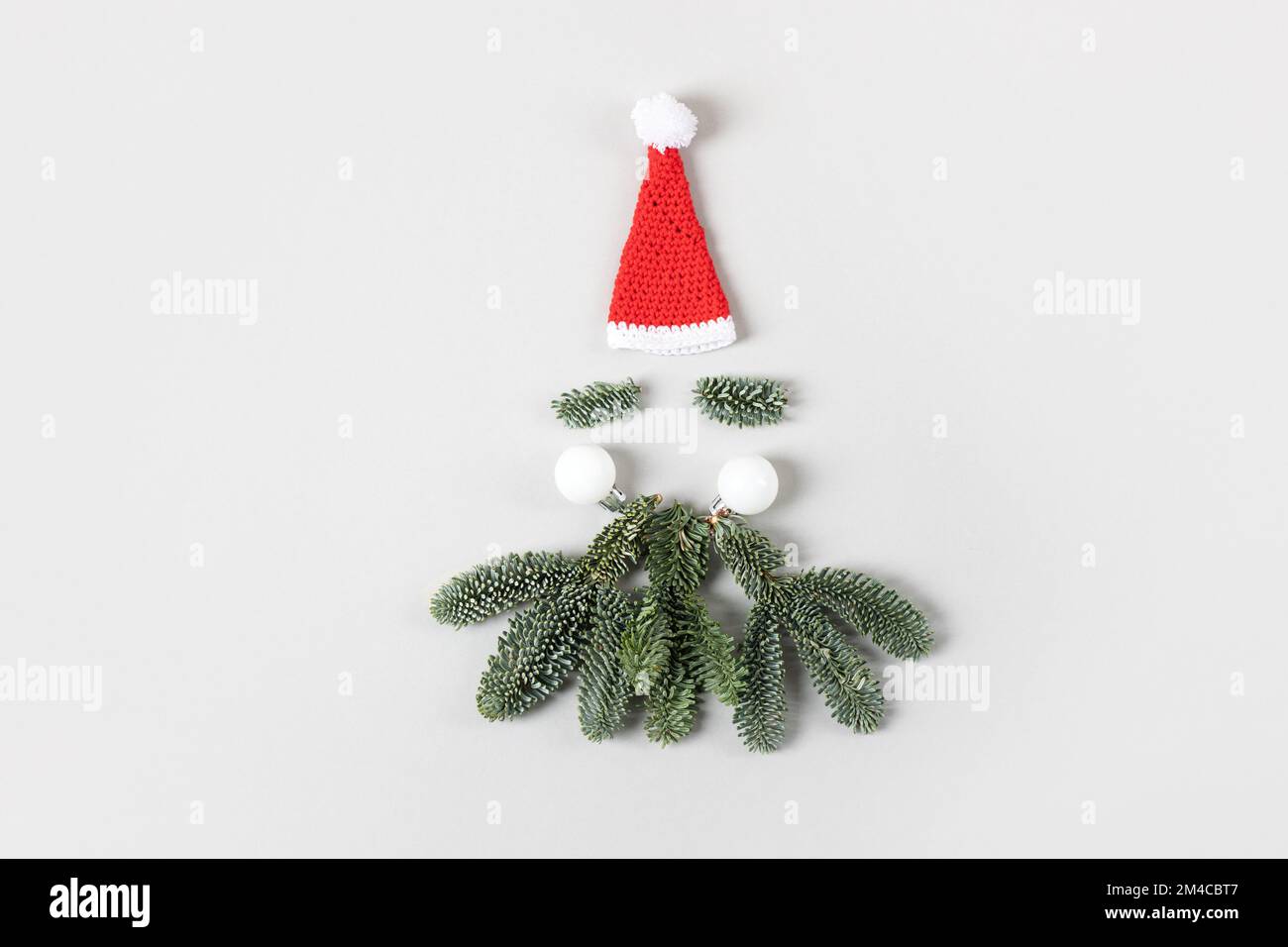 Concetto minimo di Babbo Natale. Composizione creativa di Natale. Cappello di Babbo Natale, barba fatta di rami di albero di Natale Foto Stock