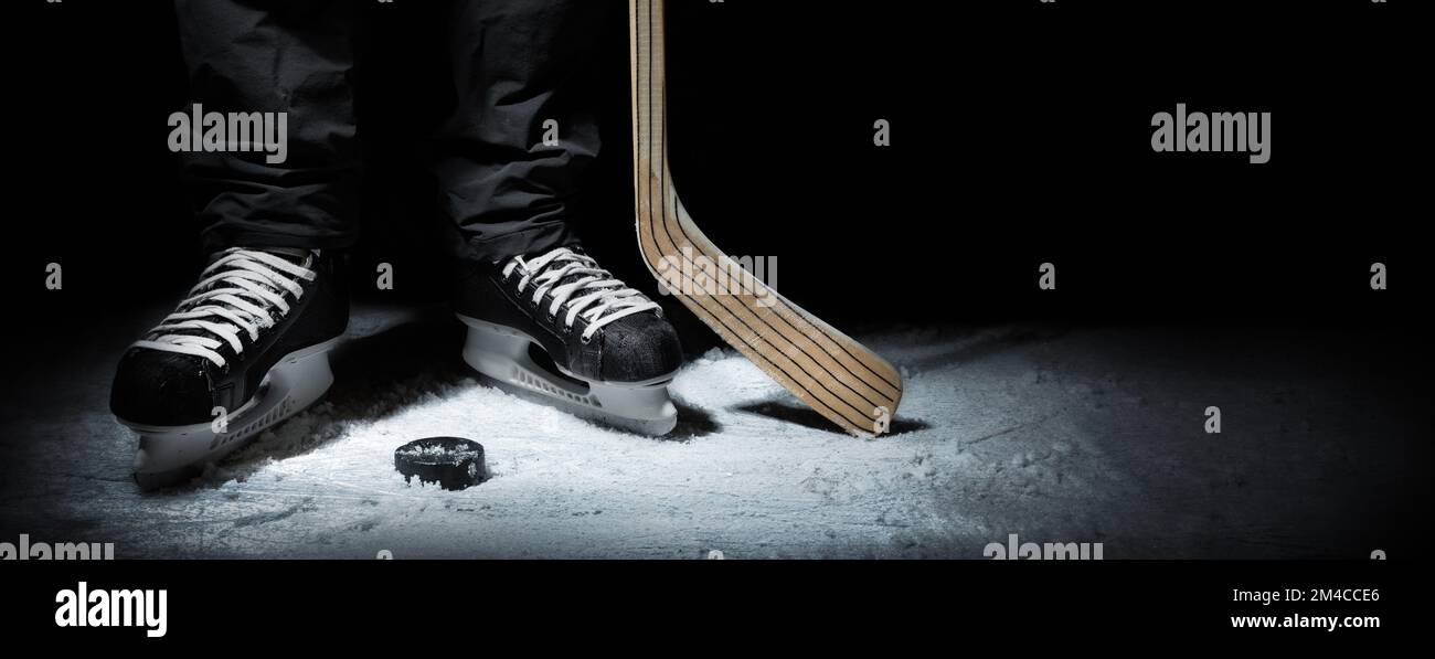 hockey su ghiaccio. primo piano dei pattini del giocatore con bastone e puck. banner con spazio di copia Foto Stock