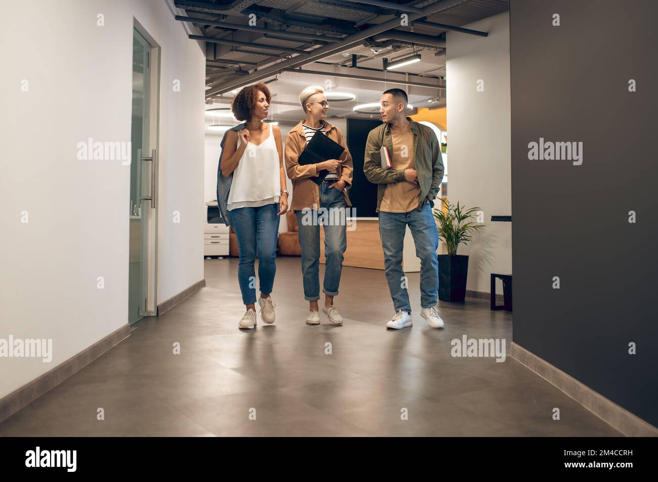 Gli impiegati che hanno una conversazione nel corridoio dell'azienda Foto Stock