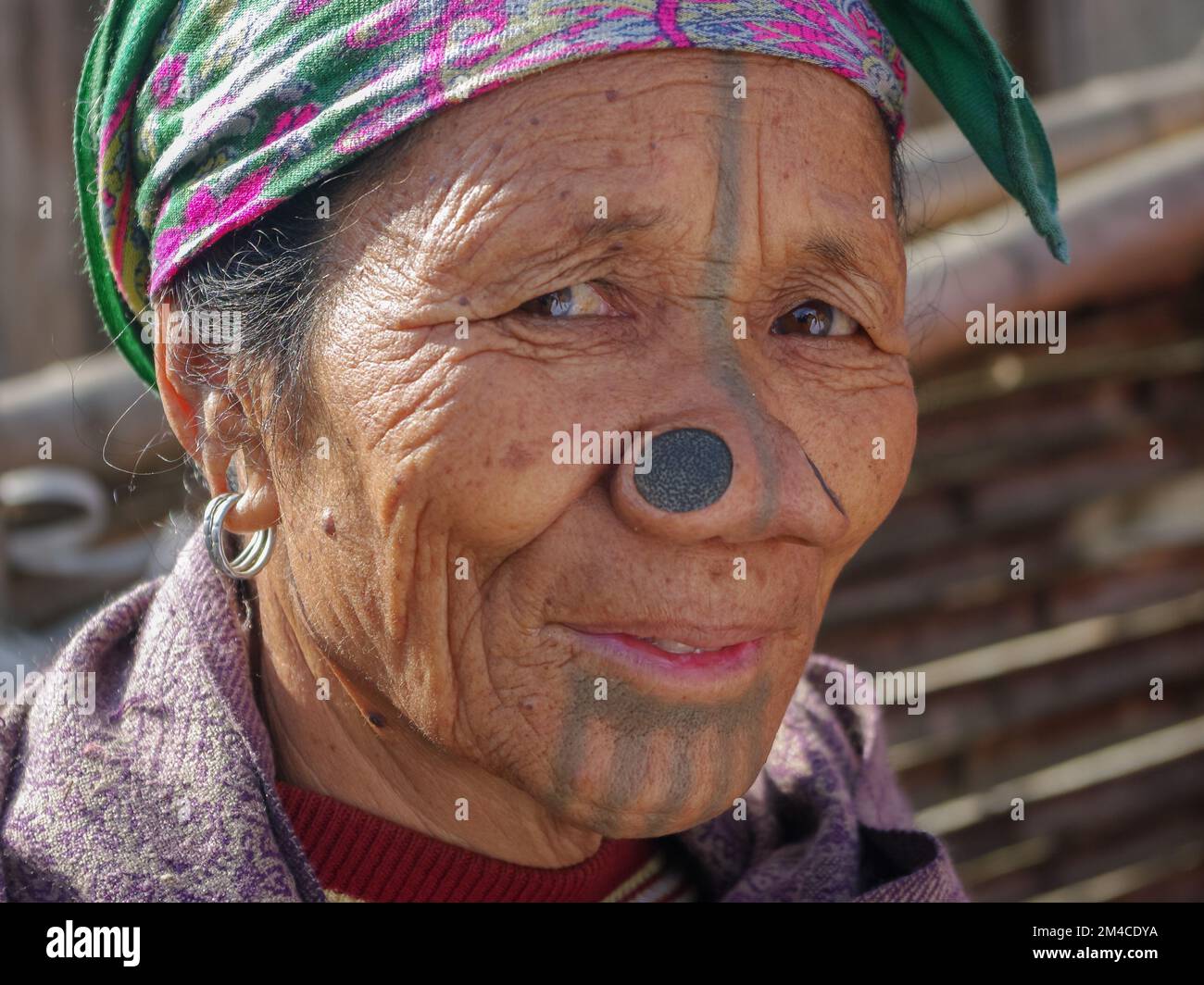 Ziro, Arunachal Pradesh, India - 02 19 2013 : Ritratto della donna tribale di mezza età di Apatani con tatuaggi facciali tradizionali e tappi per il naso Foto Stock