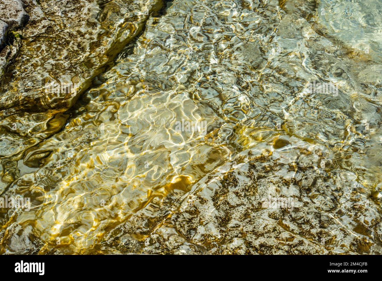 Acqua illuminata dal sole, rocce lungo la costa del lago Huron, Bruce Peninsula National Park, The Grotto Trail, Ontario, Canada Foto Stock