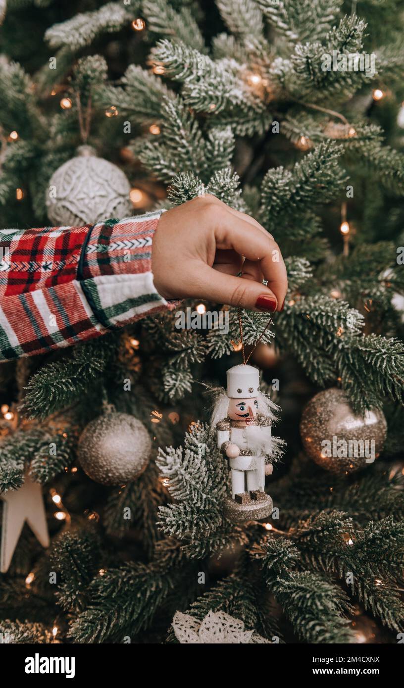 Foto ravvicinata della donna che decora l'albero di natale con ornamento soldato nutcracker Foto Stock