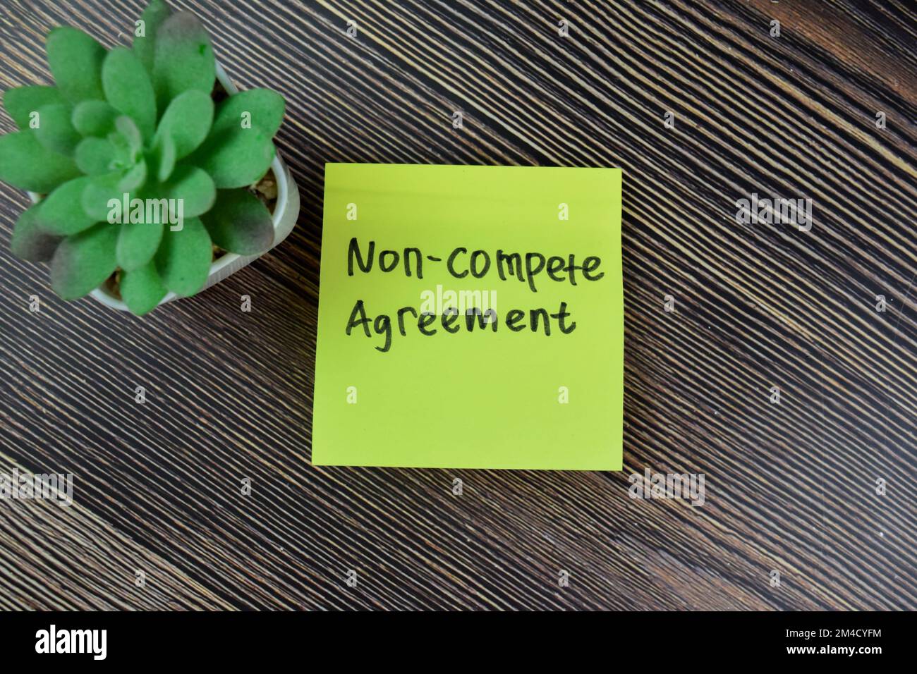 Concetto di accordo di non concorrenza scrivere su note appiccicose isolate su tavola di legno. Foto Stock