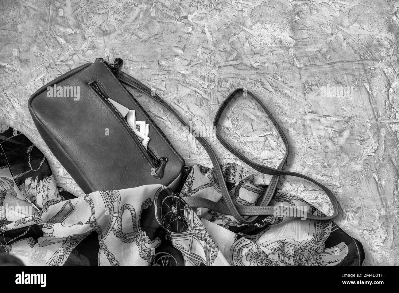 Una piccola pochette da donna accanto ad altri accessori. Denaro e una carta sono visibili da una tasca aperta. Vista dall'alto, posizione piatta, spazio di copia. Foto Stock