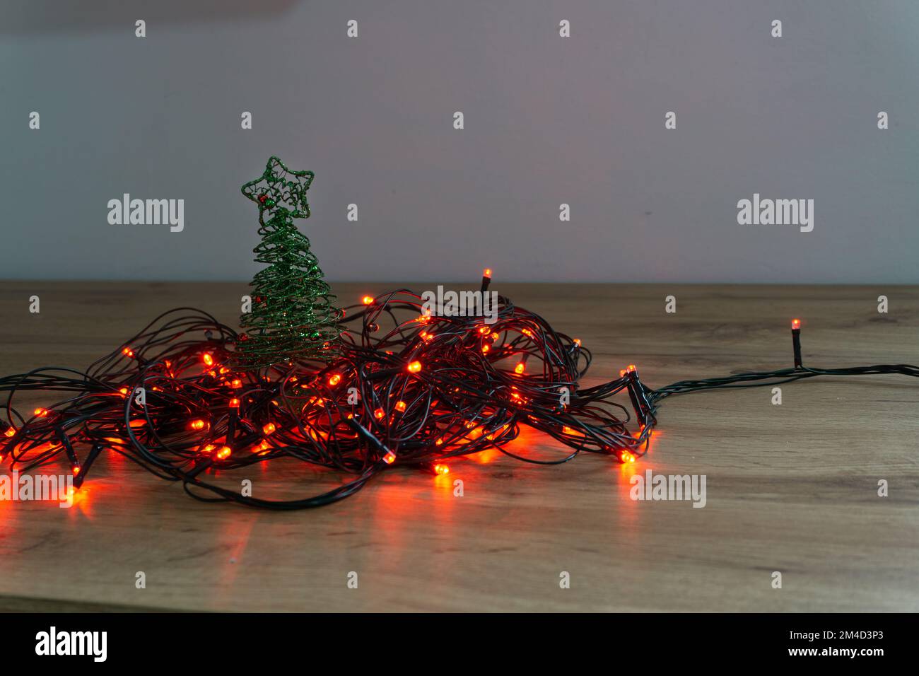 luci rosse di natale aggrovigliate su un tavolo di legno Foto Stock