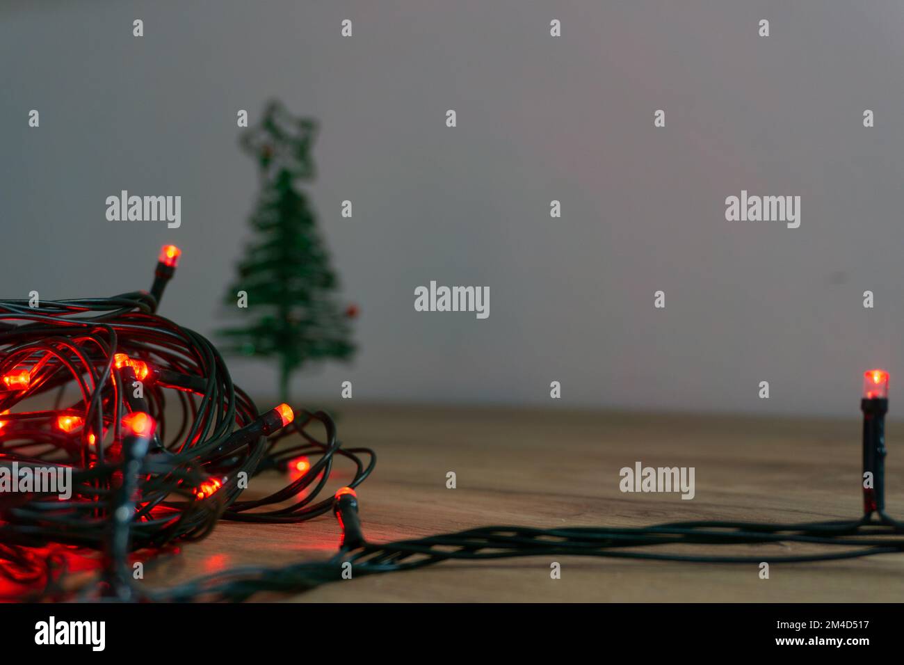 luci rosse di natale aggrovigliate su un tavolo di legno Foto Stock