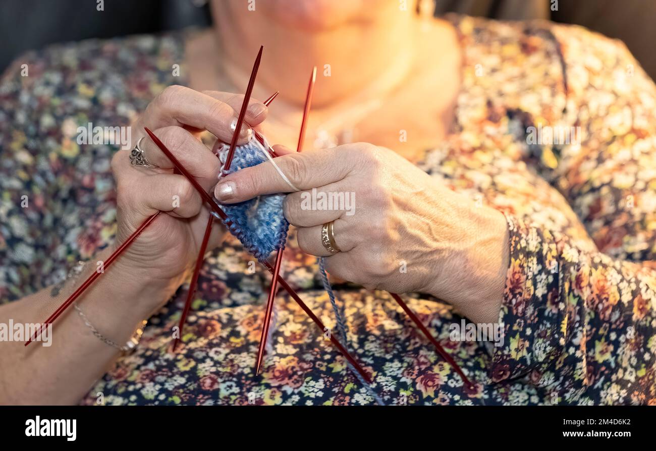 Donna anziana che si inginocchiava e guardava la TV allo stesso tempo Foto Stock