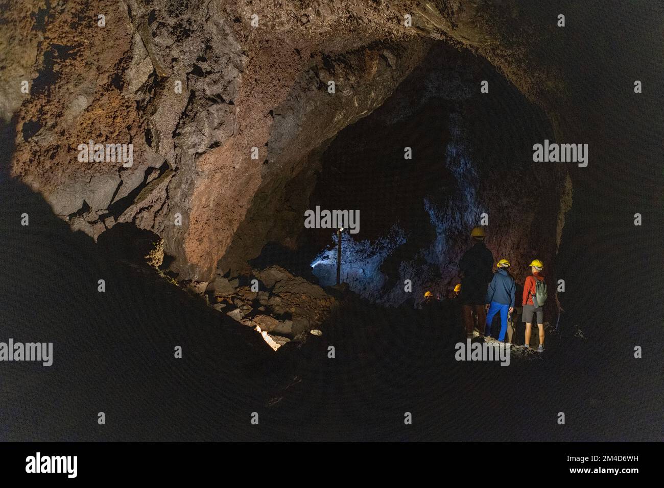 Gruppo esplorando una grotta vulcanica nel Parco delle grotte vulcaniche ai piedi del vulcano Villarrica a Pucon, Cile Foto Stock