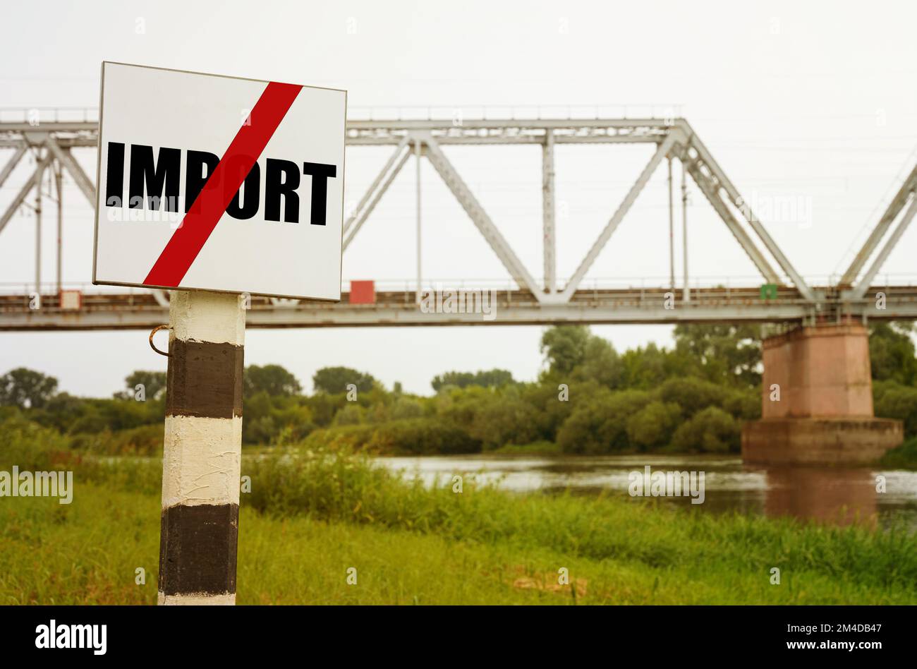 Sullo sfondo del ponte ferroviario c'è un cartello con l'iscrizione - NO IMPORT. Foto Stock