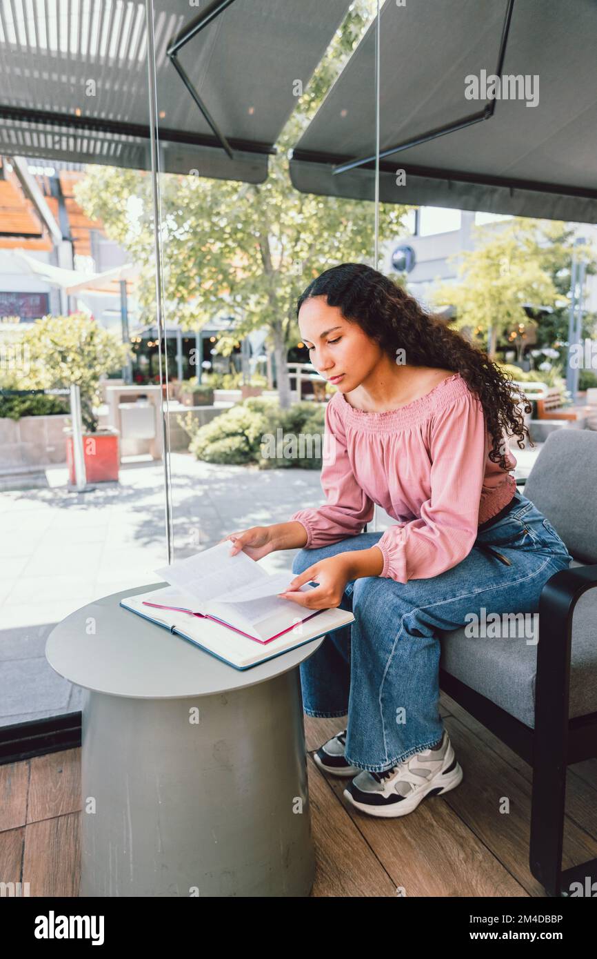 Studentessa del college latino seduta e studentessa per un esame. Verticale Foto Stock