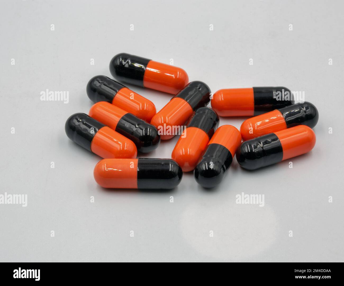 Capsule mediche arancione nero primo piano su sfondo wtite Foto Stock