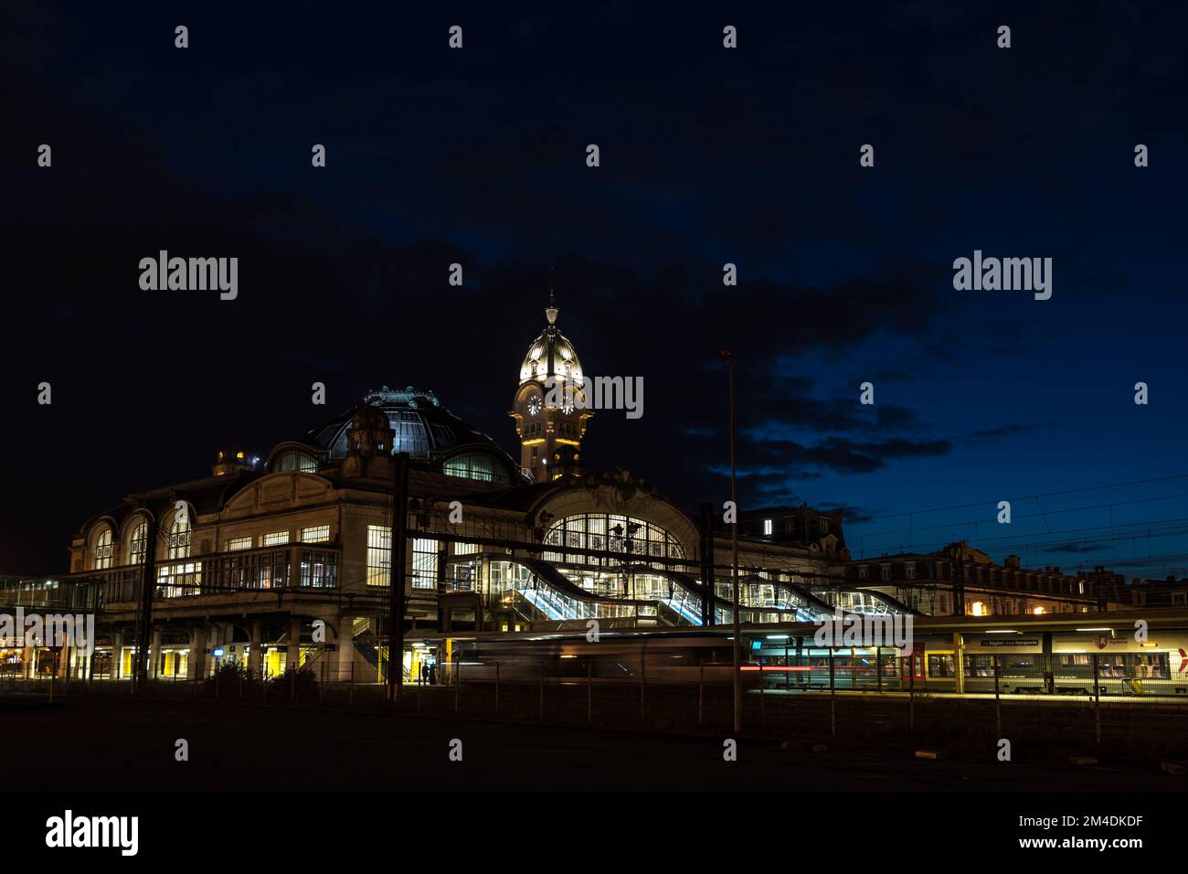 Illuminata Benedictins Stazione ferroviaria di Limoges City, di notte, con un treno in arrivo Foto Stock