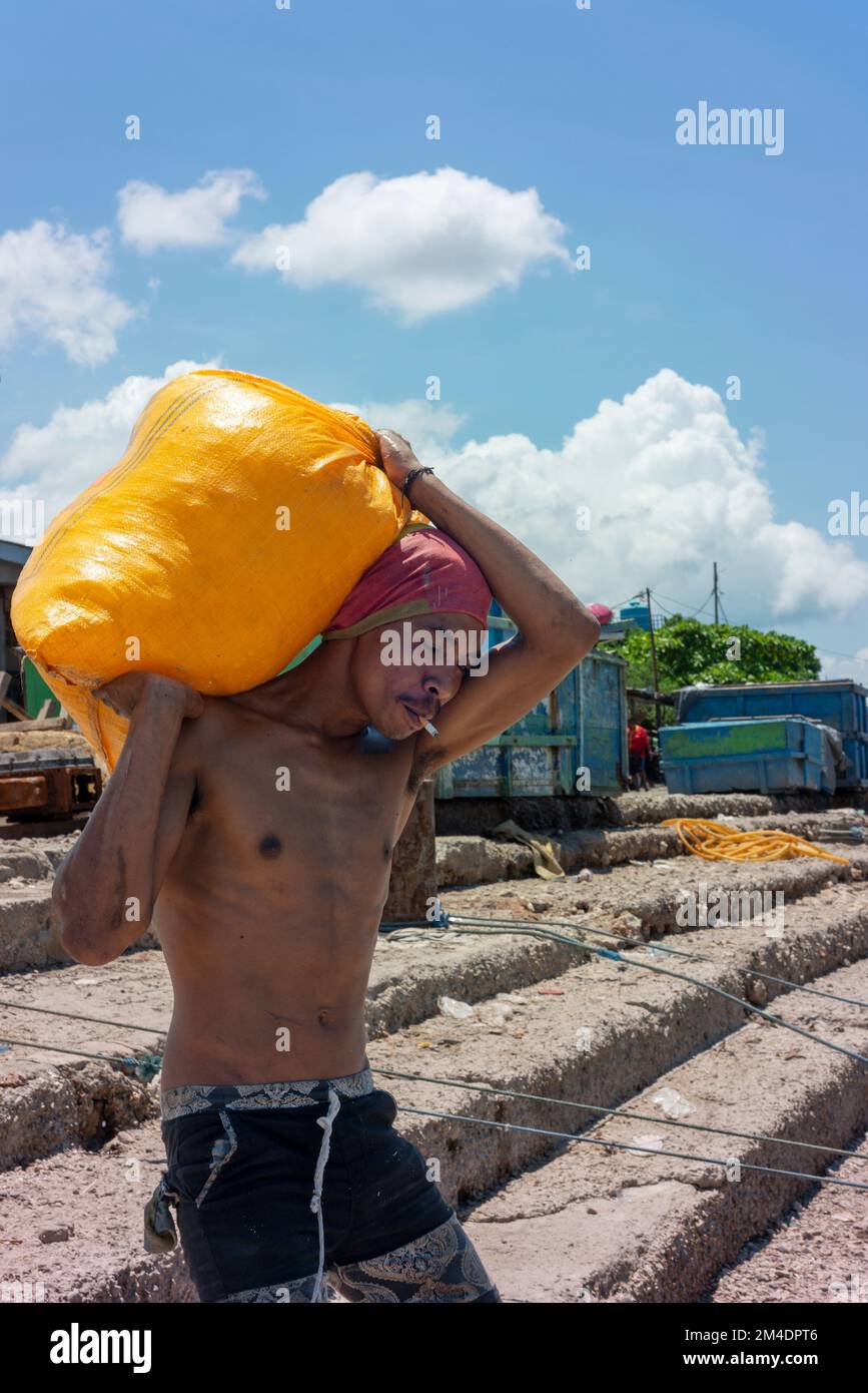 Labourer al porto di pescatori di Kupang. Foto Stock