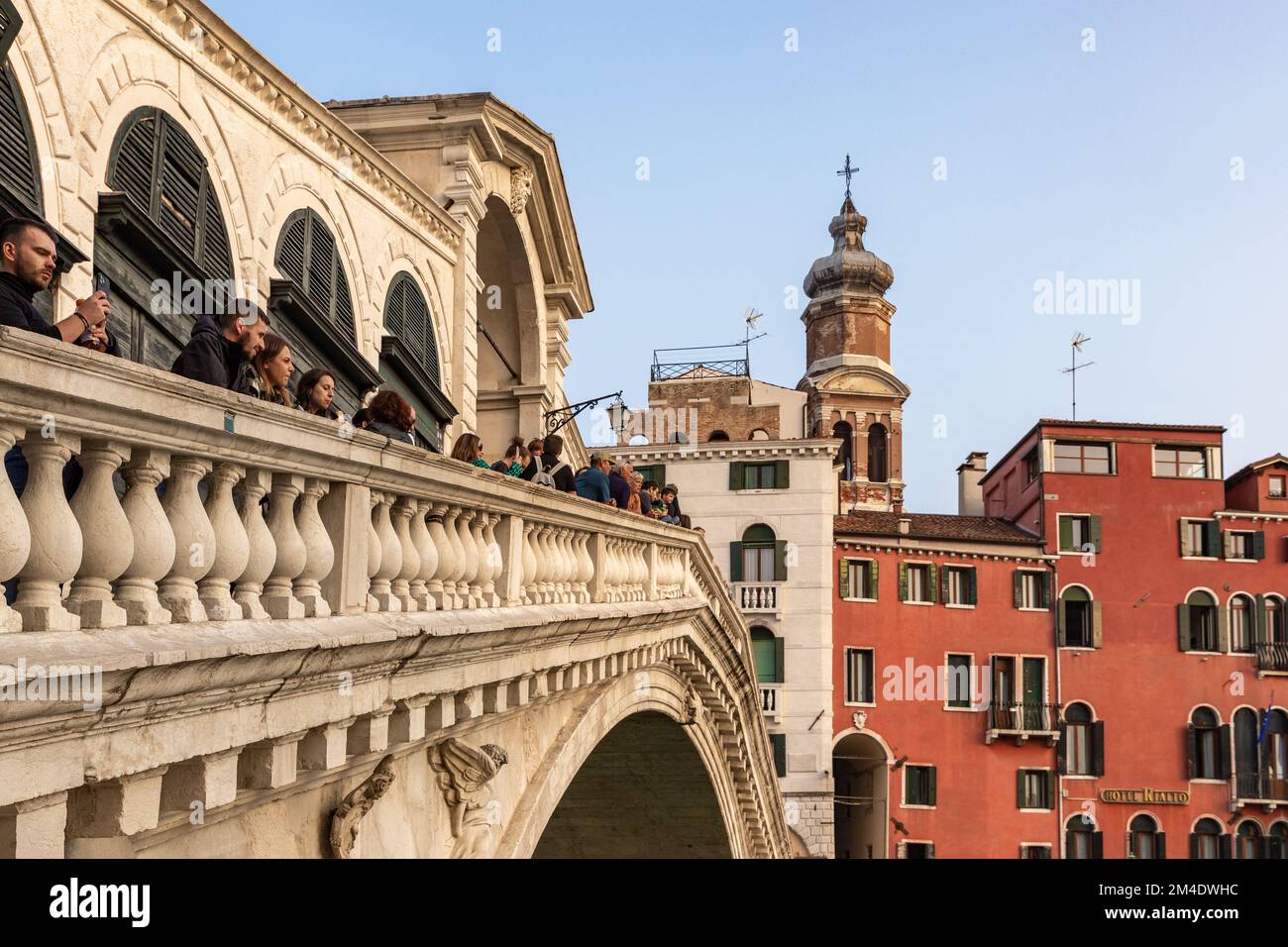 La vista sul Ponte di Rialto sul Canal Grande a Venezia. I turisti soggiornano sul Ponte di Rialto e guardano le gondole e le barche sul Canal Grande. Foto Stock