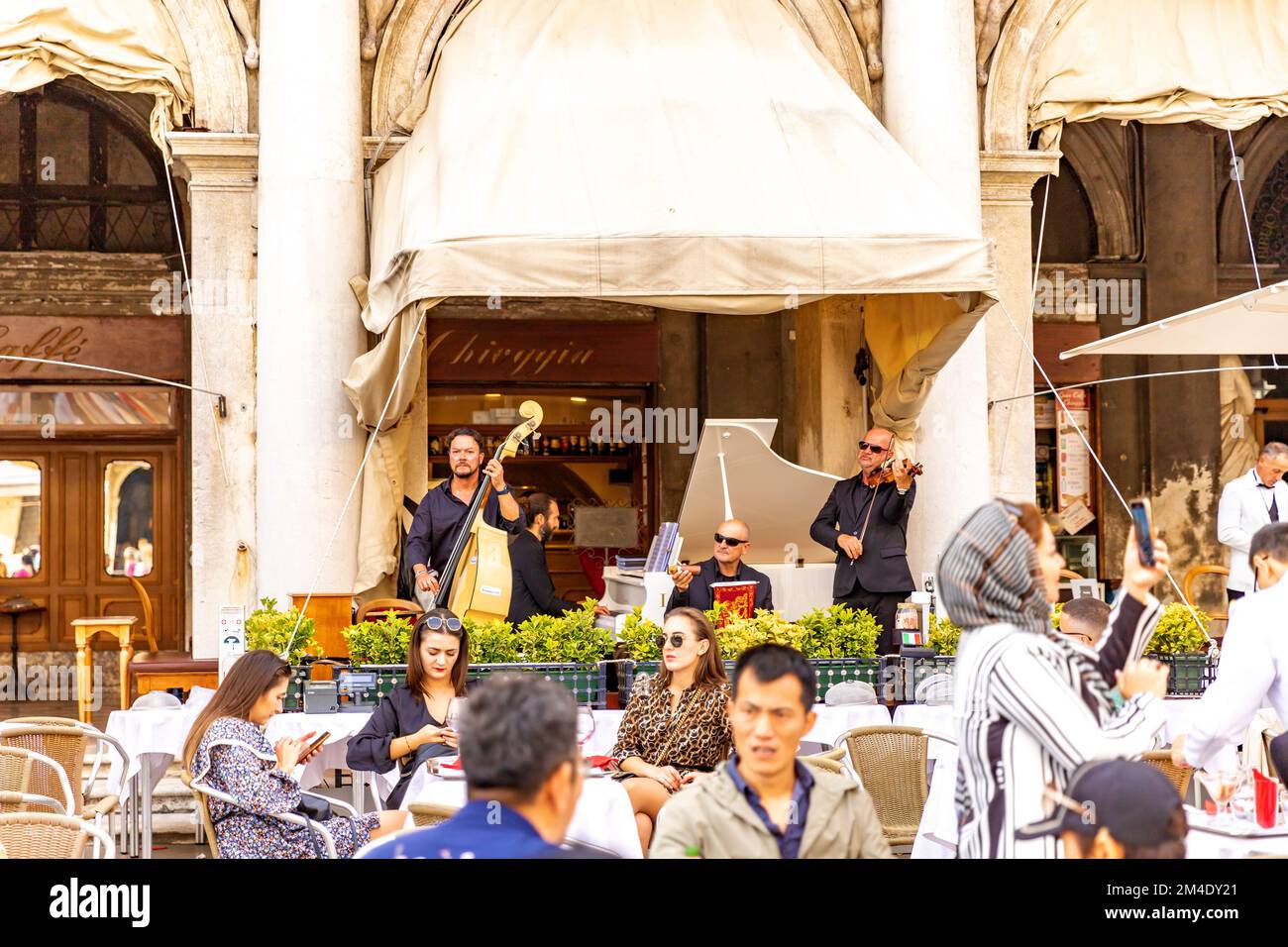 Musica dal vivo al Gran caffe Chioggia in Piazza San Marco a Venezia. Musicisti nella caffetteria di San Marco. I turisti hanno caffè, aperol, fare foto. Foto Stock