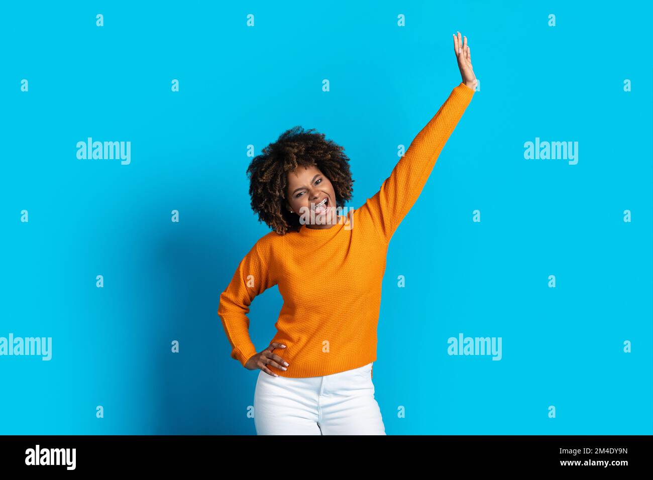 Gioiosa giovane afroamericana che si muove sul blu Foto Stock