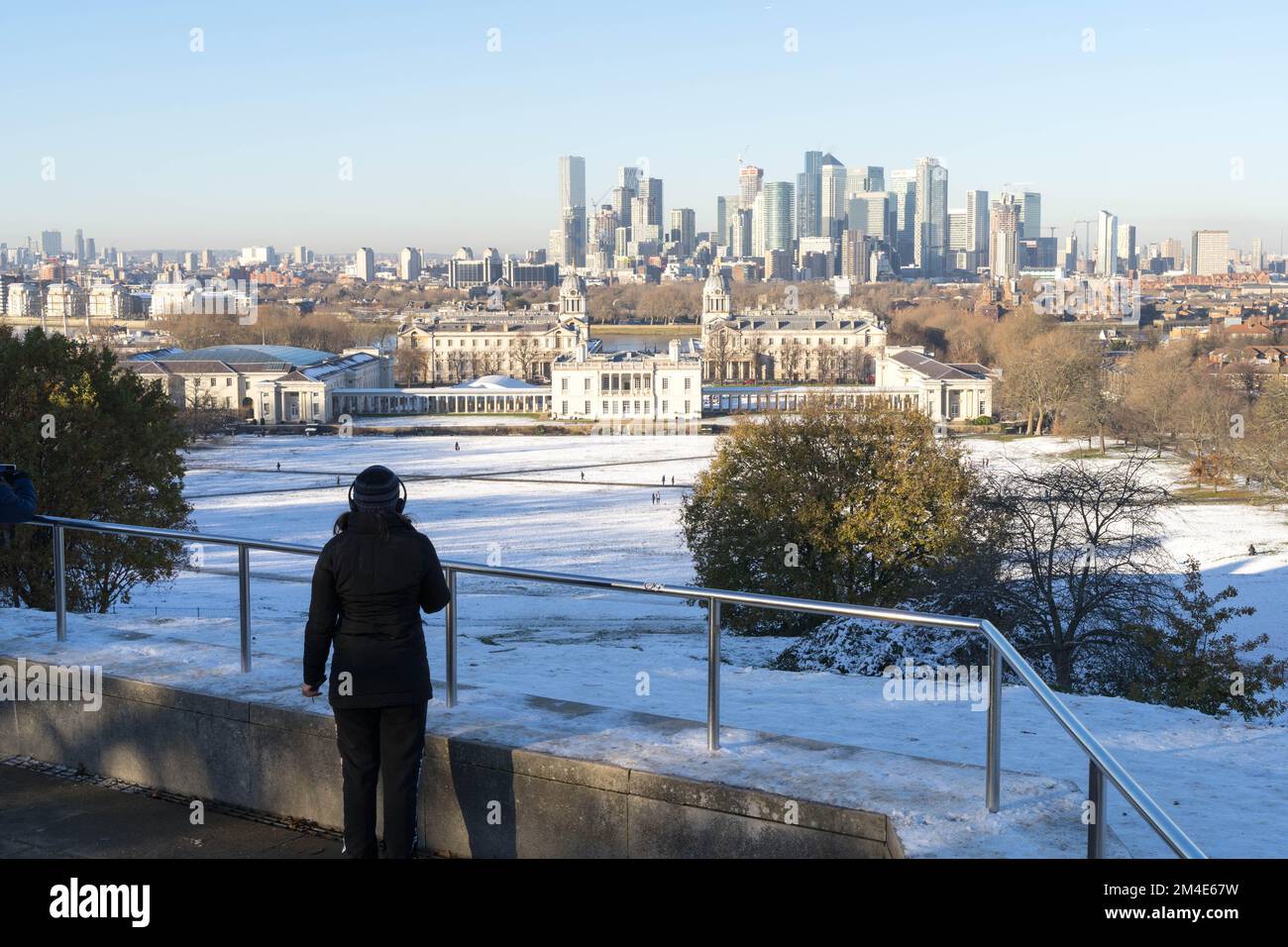 Il pubblico generale gode di un po' di sole invernale in un gelo profondo sotto la neve artica a Greenwich, nel sud-est di Londra, Inghilterra Foto Stock