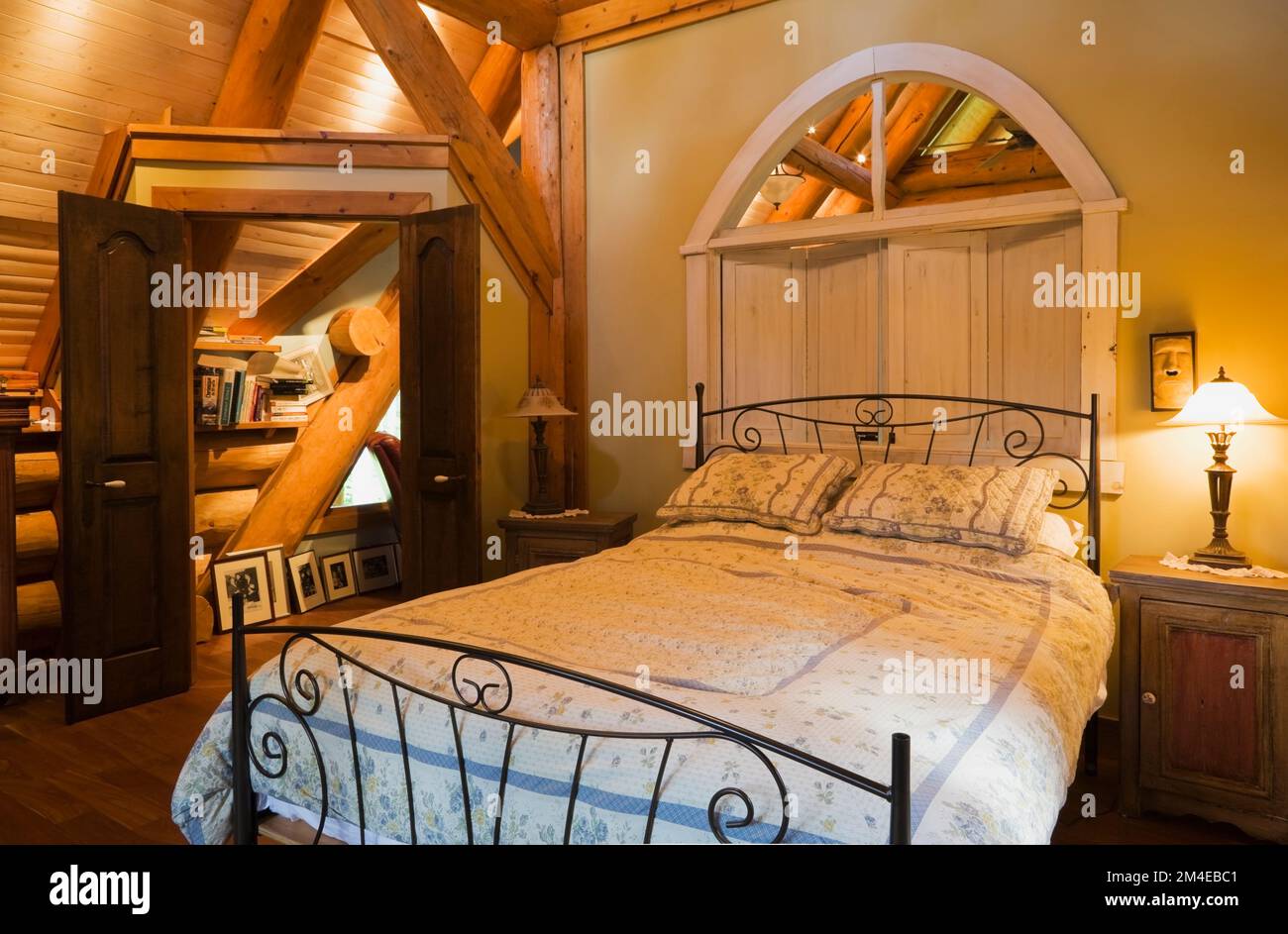 Antico letto matrimoniale nella camera da letto principale al piano superiore all'interno di una casa in legno costruita nel 2003 in stile cottage. Foto Stock