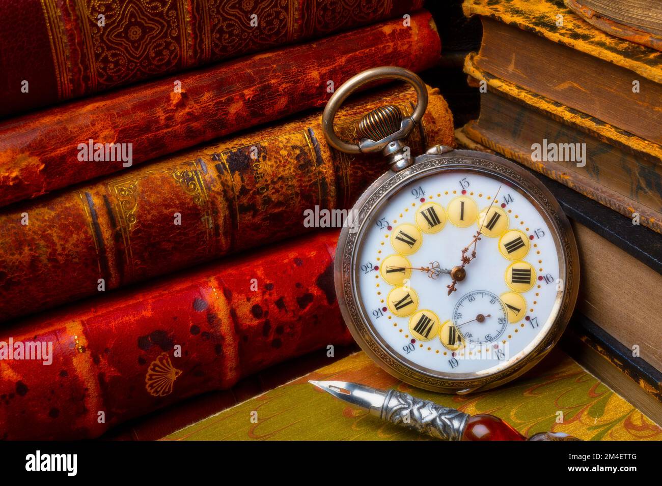Bellissimo orologio da tasca vecchio e libri impilati con penna Still Life Foto Stock