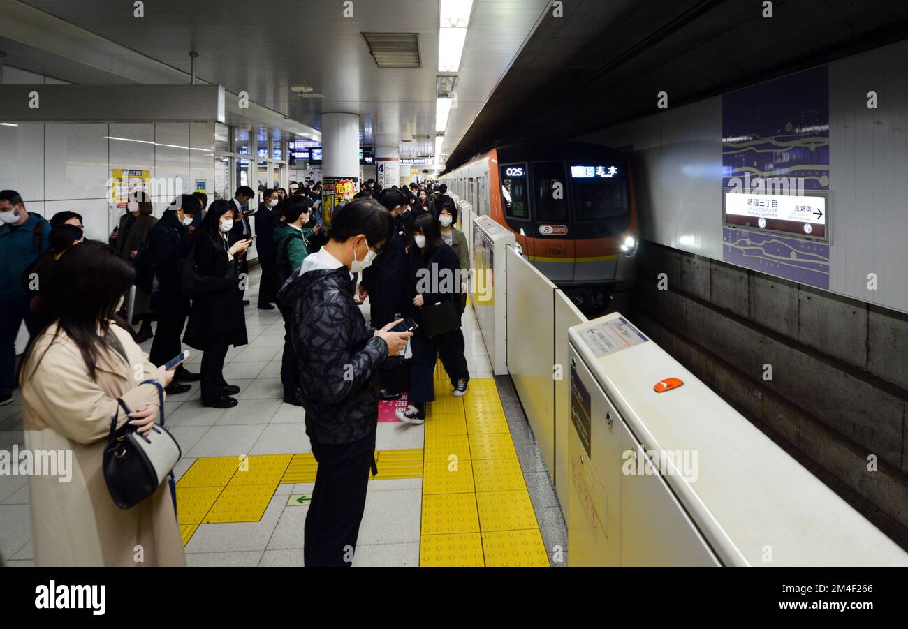 Passeggeri giapponesi in attesa di salire a bordo del treno della metropolitana a Tokyo, Giappone. Foto Stock