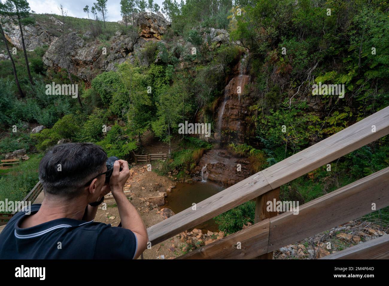 Persona che fotografa la cascata da Fraga D'alta e il passaggio pedonale a Orvalho, Portogallo, Europa Foto Stock