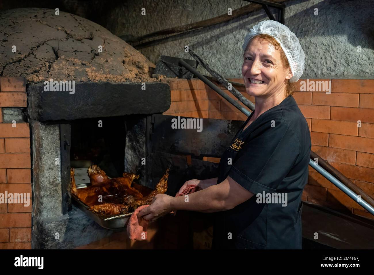 Cuocere prendendo il Cabrito estonado - tradizionale piatto di capra arrostito al forno portoghese dalla regione di Oleiros, Portogallo, Europa - fuori dal forno Foto Stock