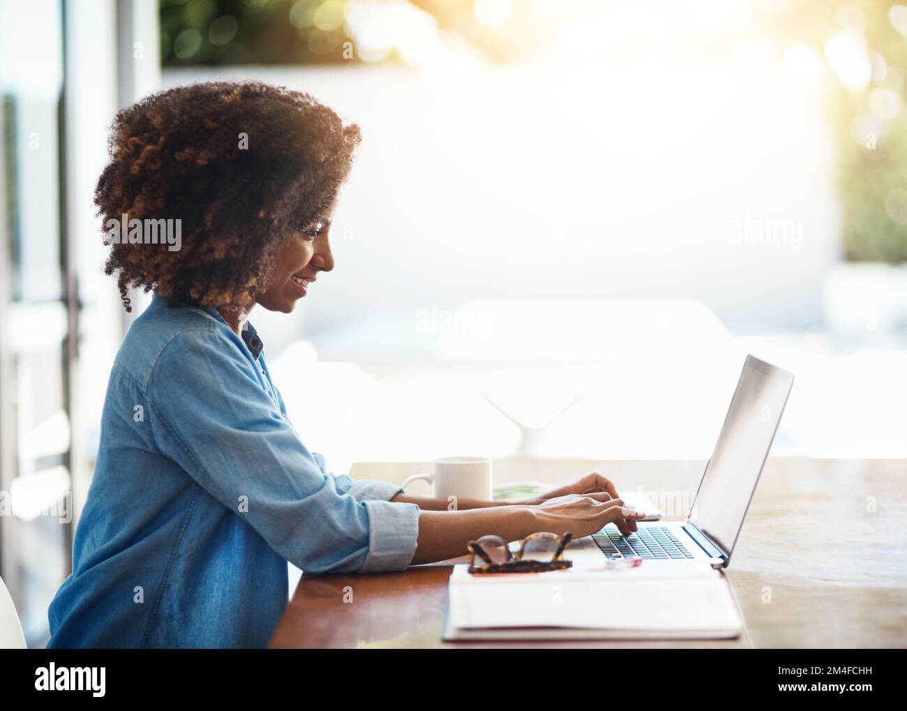 Lavorare in uno spazio confortevole aumenta davvero la vostra creatività. una giovane donna attraente che lavora sul suo notebook a casa. Foto Stock