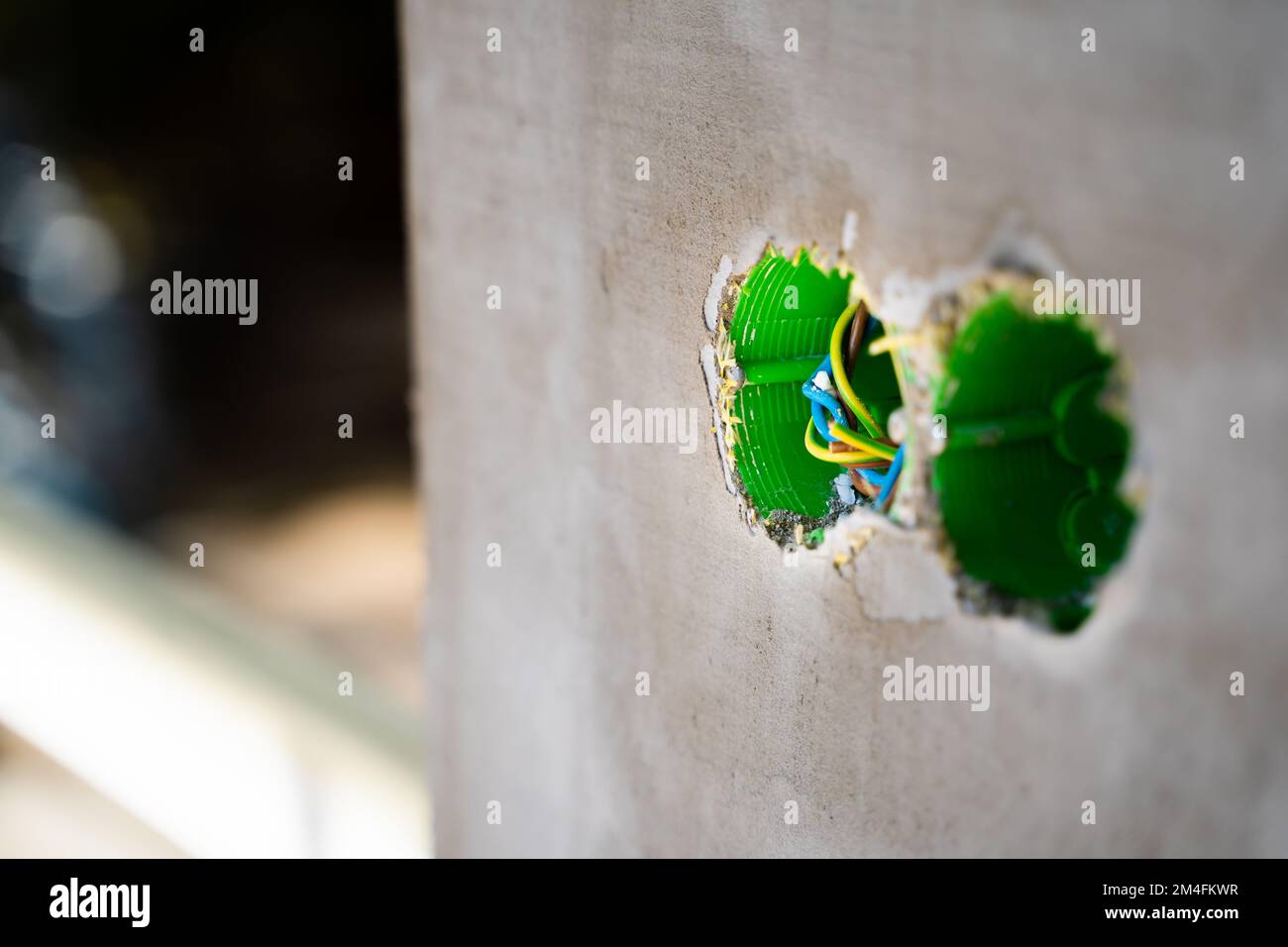 Due prese verdi con fili sono incorporate nella facciata della casa per le prese di strada. Ipoteche di plastica nella parete sulla strada per elettrico ou Foto Stock