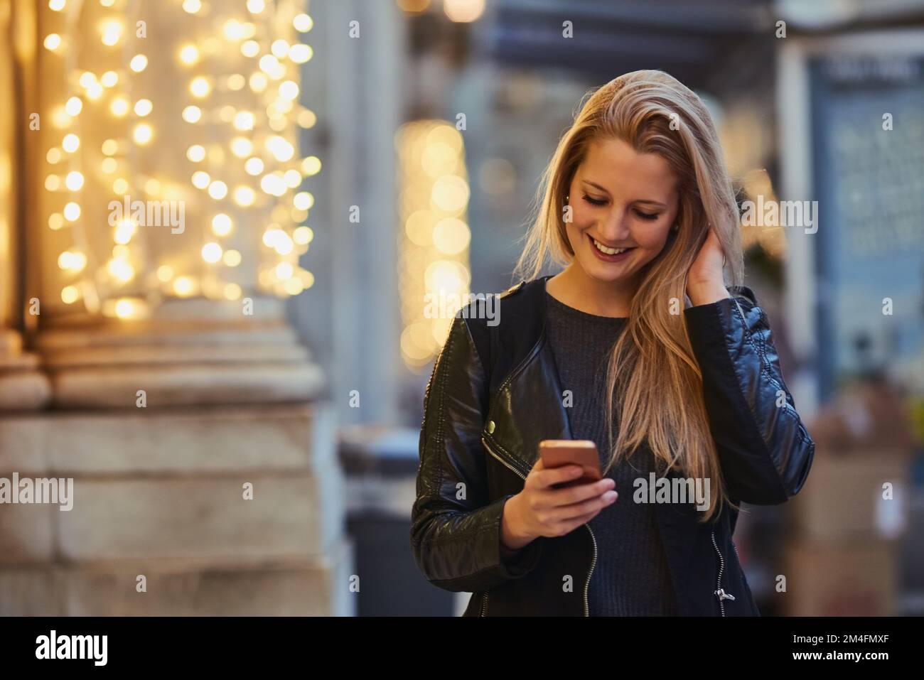 Lo smartphone, un must per qualsiasi abitante della città. una donna attraente che utilizza un telefono cellulare in città. Foto Stock