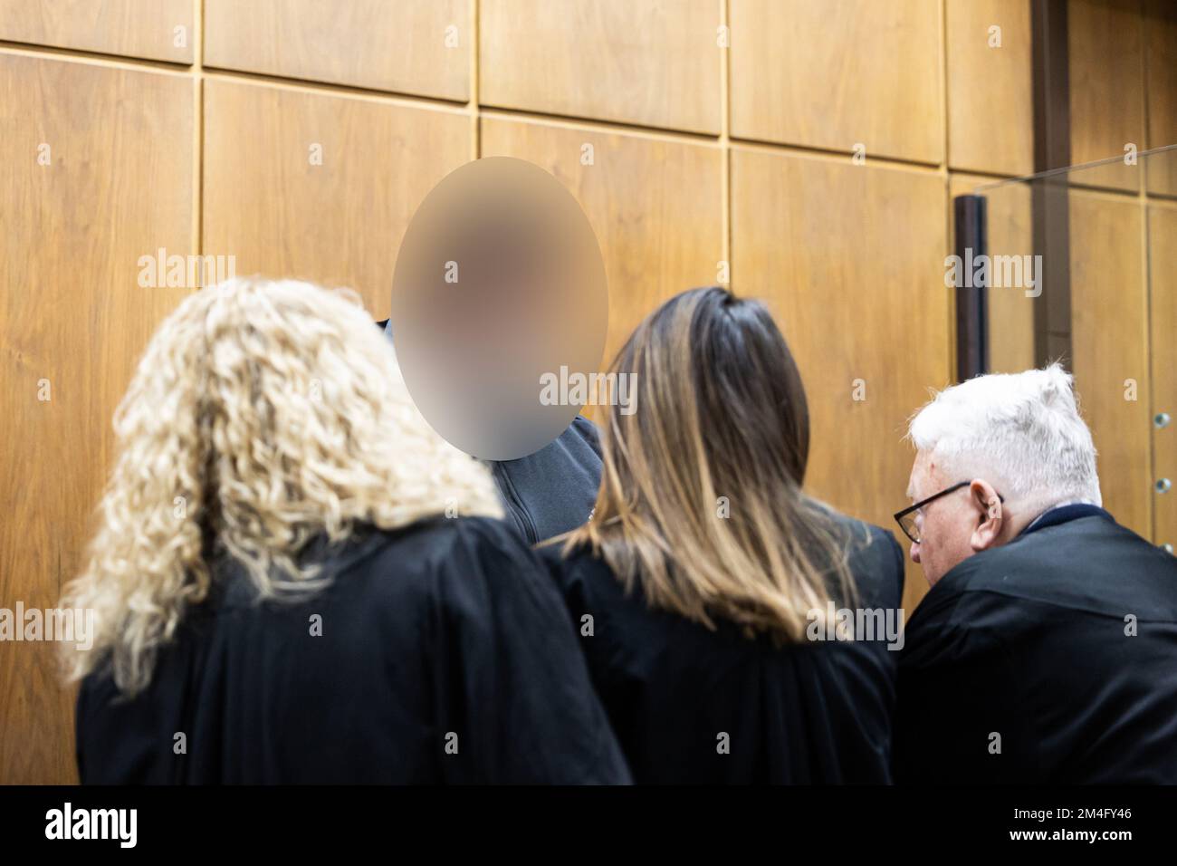21 dicembre 2022, bassa Sassonia, Hannover: L'imputato (2nd da sinistra) parla con i suoi avvocati Fritz Willig (r), Yana Tchelpanova (2nd da destra) e Silke Willig (l) in un tribunale della Corte Regionale di Hannover prima dell'inizio del processo. L'imputato è accusato di aver ucciso un uomo con diverse ferite da coltello nella sua casa a Wennigsen nel giugno 2022. Quando la moglie dell'uomo ucciso incontrò l'imputato poco dopo il crimine, presumibilmente la uccise anche con diversi pugnali di coltello per coprire il suo precedente crimine. Foto: Michael Matthey/dpa - ATTENZIONE: La(e) persona(e) è stata pixelata per le reas legali Foto Stock